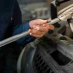 a person holding a wrench. Quality Inspection Tools in the Automotive Industry